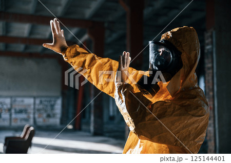Nuclear explosion. Man dressed in chemical protection suit in the ruins of the post apocalyptic building 125144401