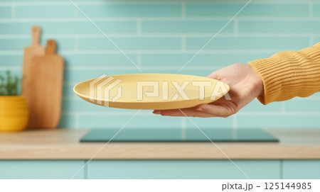 Empty plate held in a kitchen setting 125144985