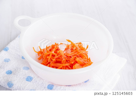 塩もみした人参に調味料を加えて休ませる 125145603
