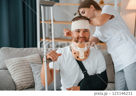 Taking care of bandage on the head. Woman is helping injured man at home 125146231