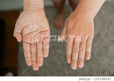 Detailed view of infant hands after bath time, palms in opposite directions. Soft baby skin and subtle wrinkles reflect the warmth and serenity of bath time. Detailed view of infant hands after bath time, palms in opposite directions. Soft baby skin and subtle wrinkles reflect the warmth and serenity of bath time. 125146422