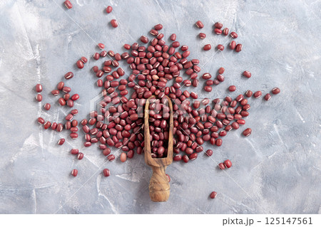 Scoop full of dried azuki beans on gray top view. East Asian legumes, vegetarian protein source Scoop full of dried azuki beans on gray top view. East Asian legumes, vegetarian protein source 125147561