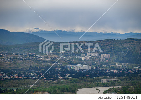 Cityscape view of Tbilisi, the capital of Georgia with snow-capped Caucasus mountains in the distance 125148011