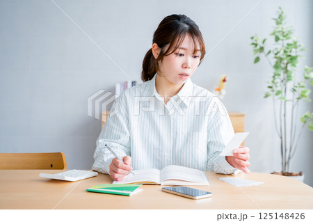 家計簿をつける女性 家計簿をつける女性 125148426