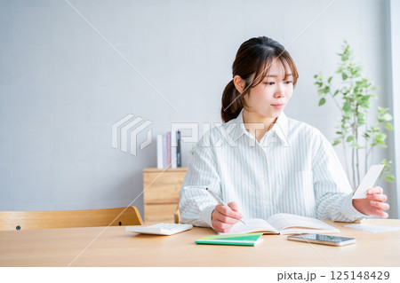 家計簿をつける女性 125148429