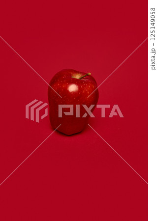 Vibrant red apple against deep red background. Healthy eating promotion, fresh produce, health, nutrition. 125149058