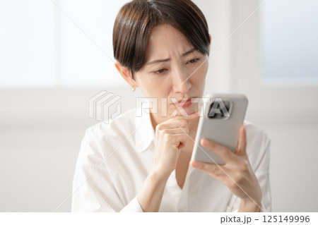スマホを見て困った顔の女性 スマホを見て困った顔の女性 125149996