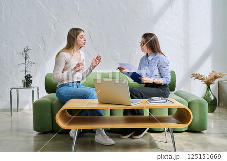 Serious young woman in session in office of professional psychologist, therapist Serious young woman in session in office of professional psychologist, therapist 125151669