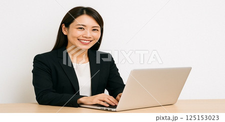 ノートパソコンを操作する笑顔の女性ビジネスパーソン(白背景) ノートパソコンを操作する笑顔の女性ビジネスパーソン(白背景) 125153023
