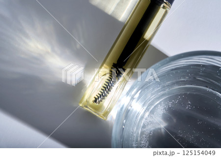 Bottle with brush filled with oil for eyebrow and eyelash growth.  125154049