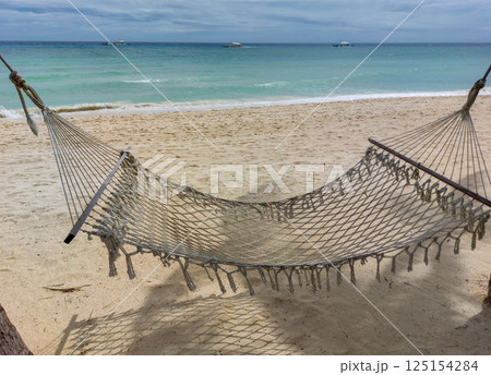 Relaxing hammock on sandy beach with turquoise water in tropical paradise 125154284