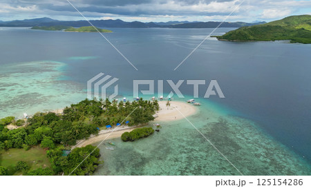 Small tropical island surrounded by distant islands 125154286