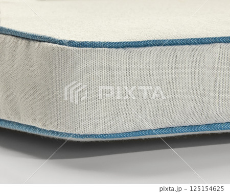 Close-up of light beige fabric with blue piping detail showing stitching and texture Close-up of light beige fabric with blue piping detail showing stitching and texture 125154625