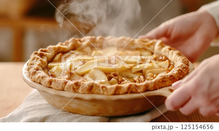 Rustic apple pie with flaky lattice crust and golden caramel filling. A cozy homemade dessert styled with powdered sugar on ceramic plate. Perfect for winter comfort food scenes. 125154656