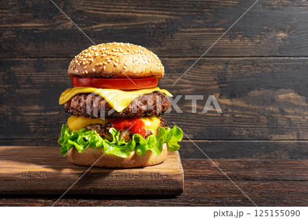 Double beef burger, cheeseburger with vegetables and melted cheese 125155090