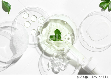 Petri dishes with green plants, pipette and cosmetic swatches Petri dishes with green plants, pipette and cosmetic swatches 125155114