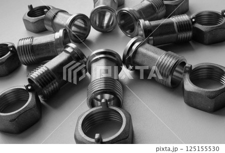 Cast Iron Water Plumbing Fittings And Fixing Nuts Laid Out On White Surface  125155530