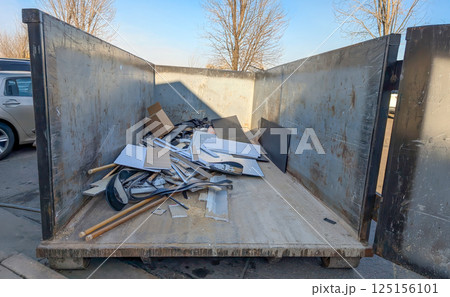 View inside an open dumpster being filled with construction debris.  125156101