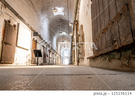 Floor level point of view of a lit cellblock of Eastern State Penitentiary historic site. 125156114