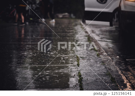 Sidewalk during a rain downpour with standing water Sidewalk during a rain downpour with standing water 125156141