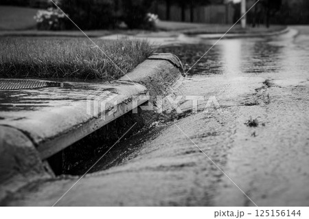 Stormwater flowing into street intake drain after a rainstorm Stormwater flowing into street intake drain after a rainstorm 125156144