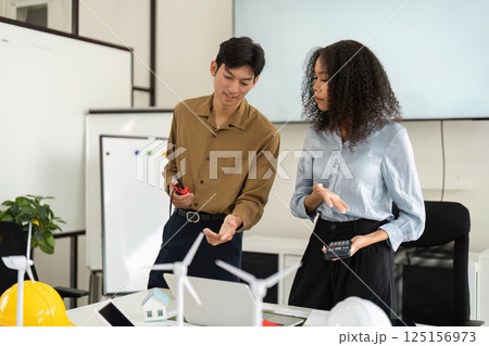 Innovative Projects and Renewable Energy. Professionals engaged in sustainable design discussions in a creative workspace. 125156973