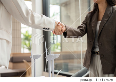 Agreement and Sustainability. Businesswomen emphasizing eco-friendly practices during a handshake. 125157026