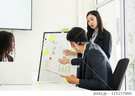 Data Analysis and Decision-Making in Sustainability. A team member elaborates on ESG metrics during a presentation. 125157060