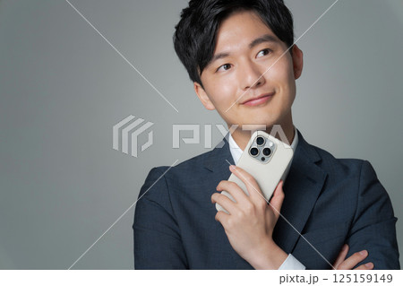スマホを持つスーツ姿の男性のポートレート 125159149