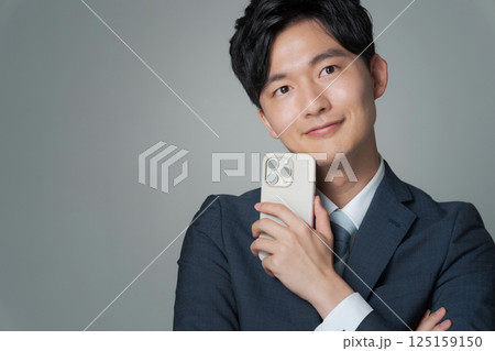 スマホを持つスーツ姿の男性のポートレート スマホを持つスーツ姿の男性のポートレート 125159150