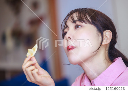 お菓子を食べる女性 お菓子を食べる女性 125160028