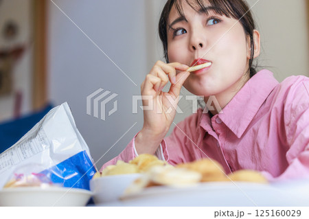 お菓子を食べる女性 お菓子を食べる女性 125160029