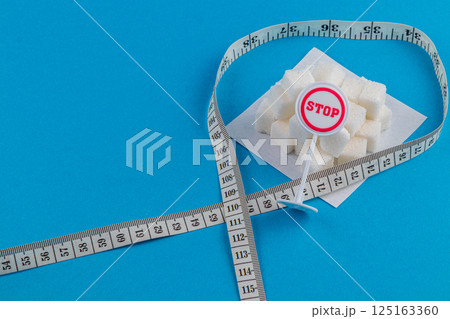 Measuring sugar cubes with a stop sign to promote healthy living choices 125163360
