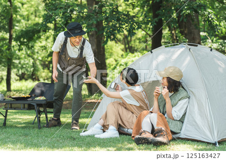 公園・キャンプ場でデイキャンプ・キャンプ・バーベキューを楽しむ仲良しのファミリー 125163427
