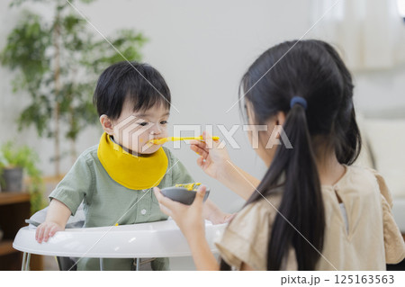 離乳食とミルクを赤ちゃんにあげる家族 離乳食とミルクを赤ちゃんにあげる家族 125163563