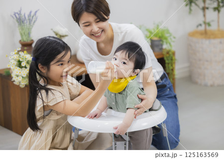離乳食とミルクを赤ちゃんにあげる家族 離乳食とミルクを赤ちゃんにあげる家族 125163569