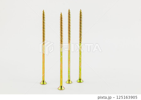 Tall metal screws arranged on a white surface Tall metal screws arranged on a white surface 125163905