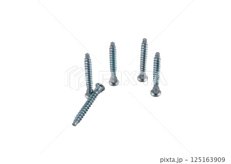 Various metal screws arranged on a light background 125163909