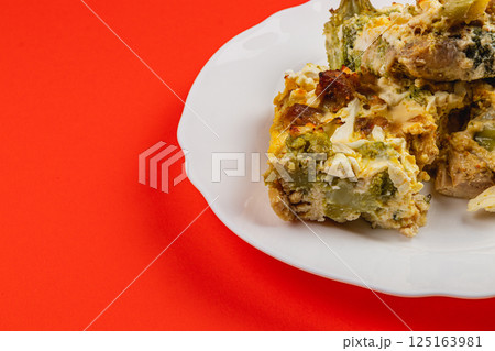 Savory casserole with chicken, broccoli, and garlic on white plate Savory casserole with chicken, broccoli, and garlic on white plate 125163981
