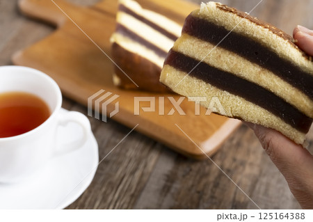 シベリア 羊羹カステラを手で持ち上げる レトロで懐かしいお菓子と紅茶 シベリア 羊羹カステラを手で持ち上げる レトロで懐かしいお菓子と紅茶 125164388