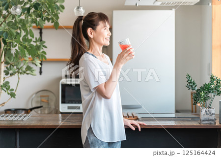 野菜ジュースを飲むスポーツウェア姿の中高年のアジア人女性(美容・栄養補給・ダイエット・美肌) 野菜ジュースを飲むスポーツウェア姿の中高年のアジア人女性(美容・栄養補給・ダイエット・美肌) 125164424