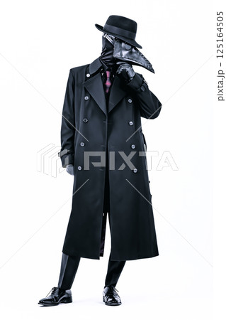 コートにスーツ姿でペストマスクを被り何かを考えているペスト医師 125164505