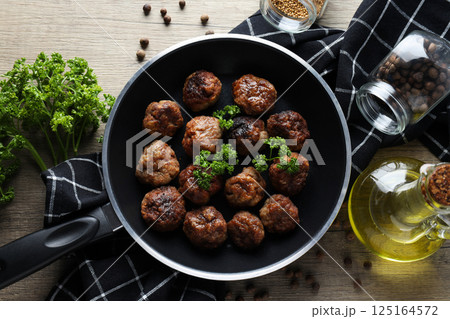 Meatballs in a pan on a wooden background Meatballs in a pan on a wooden background 125164572