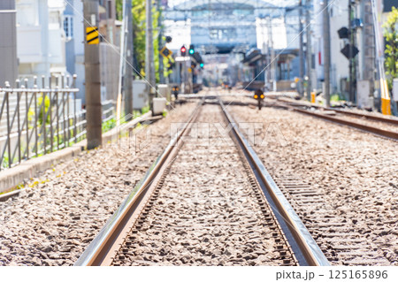 まっすぐ伸びる都会を走る電車の線路 125165896