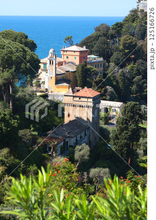 Portofino, Italy - 07 April 2025. Tourism in Italy. Traditional buildings, church, plant and trees in bay of Liguria. Background for design. Portofino, Italy - 07 April 2025. Tourism in Italy. Traditional buildings, church, plant and trees in bay of Liguria. Background for design. 125166726