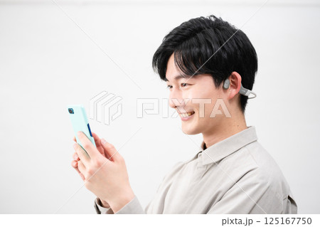 ワイヤレスイヤホンで音楽を聴く若い男性 125167750