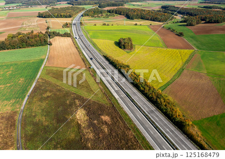 Aerial view of a two-lane highway passing through autumn nature in Germany 125168479