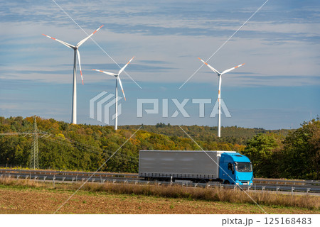 Autumn scenery with one truck on the highway and wind turbines in the background 125168483