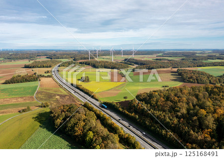 Drone image with a two-lane highway and wind turbines in an autumn set 125168491