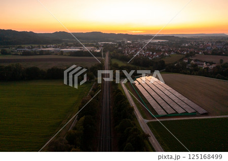 Railtracks and solar panels near a german village, drone aerial view 125168499